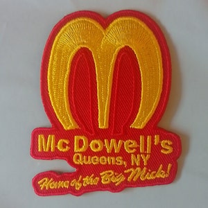 Puede incluir: Parche bordado con fondo rojo y diseño de doble arco amarillo. El parche dice "McDowell's Queens, NY" y "Home of the Big Mick!" en texto amarillo. Diseñado para ropa o accesorios.