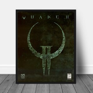 Może przedstawiać: Czarny plakat w ramie z zielonym i czarnym obrazem logo Quake II. Logo to stylizowane 'II' z okręgiem wokół. Plakat ma klasyfikację 'Mature' od ESRB.