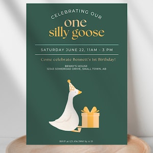 May include: A green invitation card with a white goose wearing a party hat and holding a yellow gift box. The text on the card reads "Celebrating our one silly goose, Saturday June 22, 11am - 3pm, Come celebrate Bennett's 1st Birthday! Benny's House, 12345 Somerod Drive, Small Town, AB, RSVP at 123.456.7890 by 6/15."