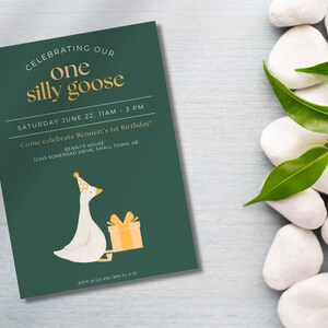 May include: A green invitation card with a white goose wearing a party hat and holding a yellow gift box. The text on the card reads "Celebrating our one silly goose" and "Saturday June 22, 11am - 3pm. Come celebrate Bennett's 1st Birthday! Benny's House 12345 Somerood Drive, Small Town, AB. RSVP at 121.456.7890 by 6/15"