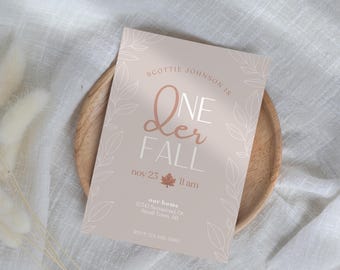 May include: A light pink invitation card with a white floral design and the text "Scottie Johnson is One Der Fall, Nov 25, 11 am, our home, 12345 Someroad Dr, STown AB, ODVP 125-150780".
