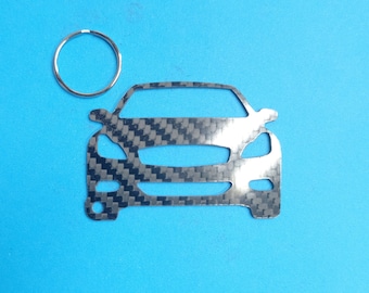 May include: A silver car keychain with a carbon fiber pattern. The keychain has a silver ring attached to it.
