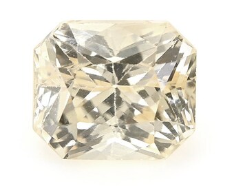 May include: A light yellow, faceted, square-shaped gemstone with a slightly rounded edge.