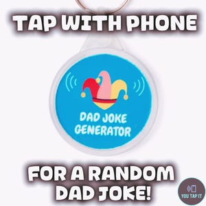 May include: A round white keyring with a blue centre featuring a colourful jester hat icon and the text DAD JOKE GENERATOR. The text TAP WITH PHONE FOR A RANDOM DAD JOKE is displayed above and below the keyring, with a small YOU TAP IT logo.