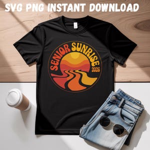 May include: Black t-shirt with a circular graphic that reads "Senior Sunrise 2026" in orange and yellow. The design features a stylized sunset over a winding road. The words "SVG PNG INSTANT DOWNLOAD" are at the top.