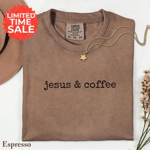 May include: Espresso-colored t-shirt with the text "jesus & coffee" in black. A gold star pendant necklace rests on the shirt. The shirt has a "Comfort Colors" tag and a "LIMITED TIME SALE" sticker.