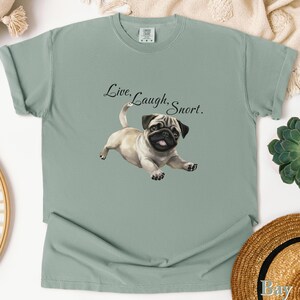 May include: A light green t-shirt with a pug dog illustration and the text "Live, Laugh, Snort."