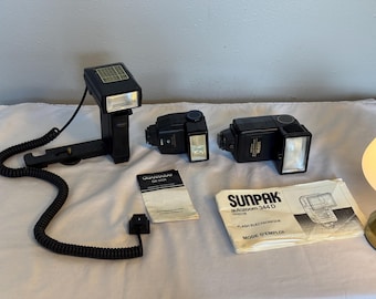 Paquete de tres flashes de tiristor para cámara vintage: 1) Sunpak Auto Zoom 344 D, 2) Flash externo con soporte, 3) Quantaray QB-350A (sin probar).