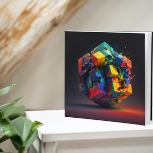 May include: A colorful cube with a swirling paint effect, printed on the cover of a square hardcover book.