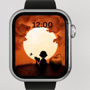 Puede incluir: Un reloj inteligente plateado con una correa negra muestra una imagen con temática de Halloween. La imagen presenta una silueta de Charlie Brown y Snoopy, una calabaza y una luna llena contra un cielo naranja. La hora 12:00 se muestra en la parte superior.