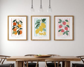 May include: Three framed art prints featuring fruit illustrations. The prints depict oranges, lemons, and strawberries, each set against a striped background. The frames are wooden, and the prints are labeled "Fruit Market".