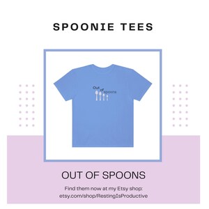 May include: A light blue t-shirt featuring the text "Out of spoons" and a graphic of five spoons. The spoons are decreasing in size, suggesting that the wearer is out of spoons, a term used to describe feeling exhausted or depleted.