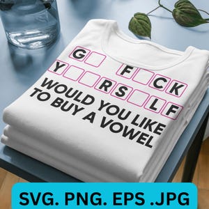 May include: White t-shirts stacked on a blue surface. The top shirt has the text "G F CK Y _ _ R S _ _ L F WOULD YOU LIKE TO BUY A VOWEL" in black and pink. The bottom of the image has the text "SVG. PNG. EPS. JPG" in a blue rectangle.