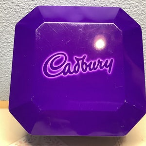 Cadbury Biscuit tin from 2002. Bright Purple container 8 sided with lid that fits sealed and tight. Could find others, but not this one,NICE