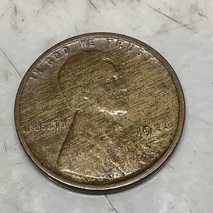 May include: A copper-colored United States one-cent coin featuring the profile of Abraham Lincoln facing right. The text IN GOD WE TRUST is arched along the top, LIBERTY is on the left, and the year 1923 with an S mint mark is on the right.