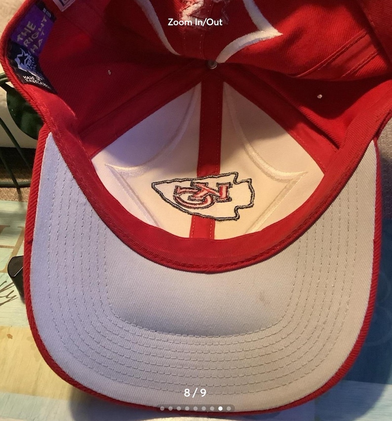 May include: Red and white baseball cap with a white embroidered Kansas City Chiefs logo on the front. The inside of the cap is white with a red brim. The size of the cap is 8/9.