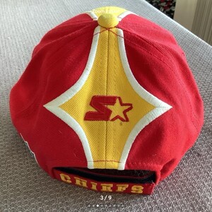 May include: Red baseball cap with a yellow star and the word "Chiefs" on the back. The cap has a white star and the letter "S" on the front.