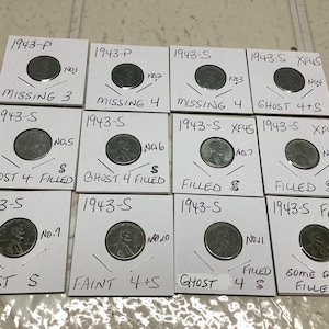 May include: A collection of 12 coin holders, each containing a 1943 Lincoln penny. The holders are labeled with details such as "Missing 3", "Ghost 4 Filled", and "Faint 4+S". The coins are displayed on a light-colored surface.