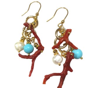 May include: Gold earrings with red coral, turquoise, and white pearls. The earrings feature a dangling design with multiple charms.