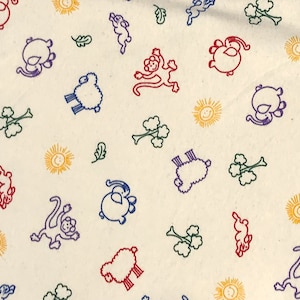 May include: Cream-colored fabric with a repeating pattern of colorful cartoon animals, suns, and leaves. The animals include monkeys, sheep, and other creatures, outlined in red, blue, and purple. The suns are yellow, and the leaves are green.