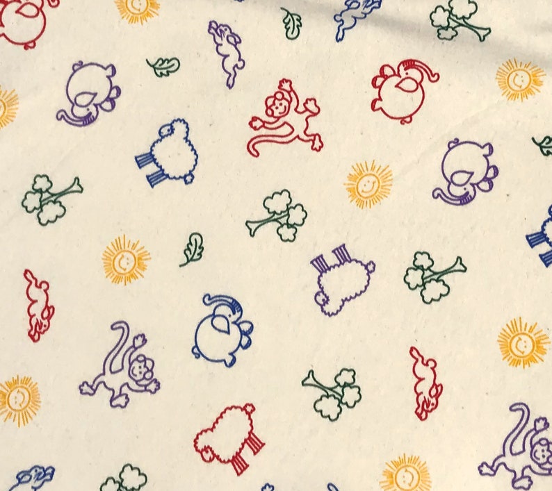 May include: Cream-colored fabric with a repeating pattern of colorful cartoon animals, suns, and leaves. The animals include monkeys, sheep, and other creatures, outlined in red, blue, and purple. The suns are yellow, and the leaves are green.
