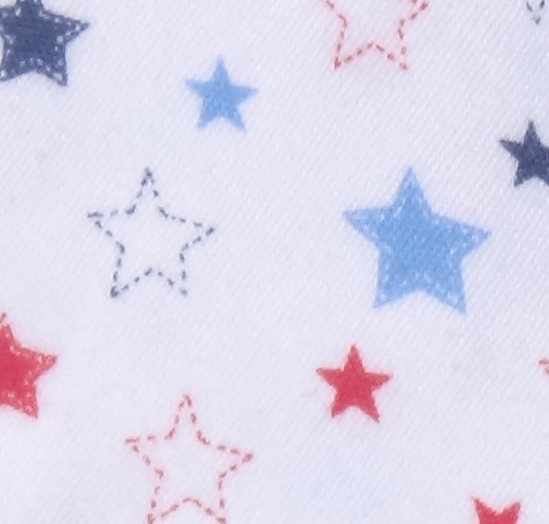 May include: White fabric with a repeating pattern of red, blue, and navy blue stars. Some stars are solid, while others are outlined with a dotted stitch. The stars vary in size and are scattered across the surface.