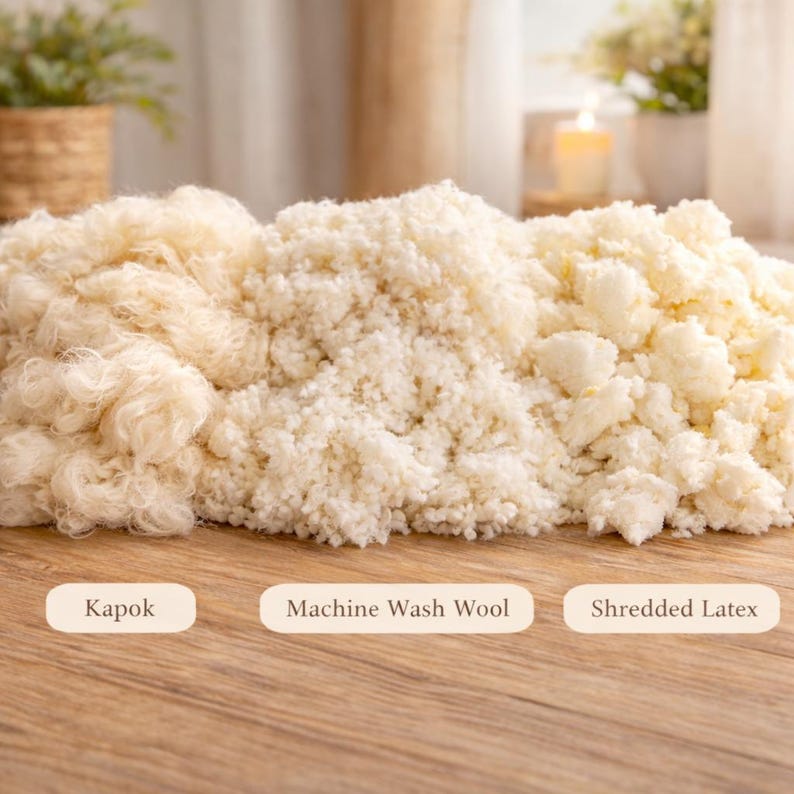 May include: A display of three distinct types of white and off-white stuffing materials arranged side by side. The left section is fibrous kapok, the center is machine wash wool, and the right section consists of small pieces of shredded latex.