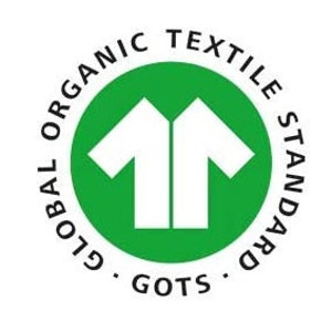 May include: A circular green logo featuring a white stylized t-shirt icon in the center. The text GLOBAL ORGANIC TEXTILE STANDARD is printed in black along the upper circular border, with the acronym GOTS positioned at the bottom center.