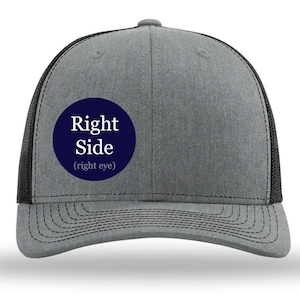 May include: A gray and black trucker hat with a navy blue circle patch that says "Right Side (right eye)".