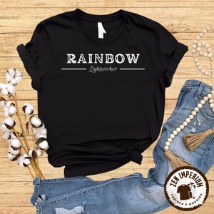 May include: Black t-shirt with white text that reads "RAINBOW Lightworker".