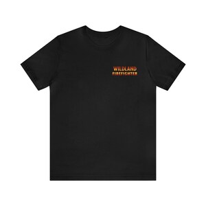 May include: Black t-shirt with the text "Wildland Firefighter" in a gradient of orange, red, and yellow.