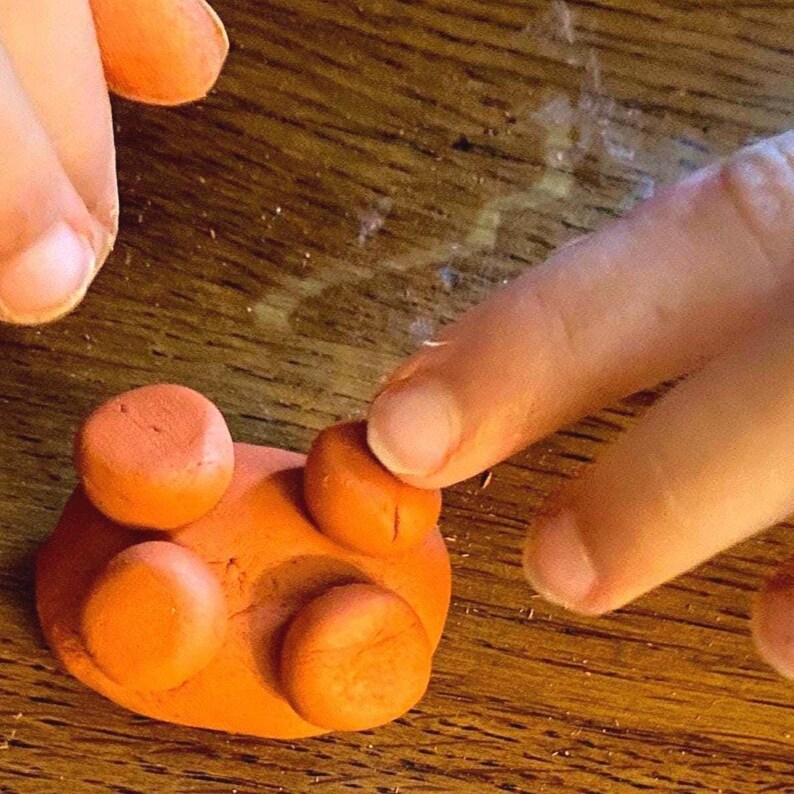 Putting little legs on my clay pig using the slip I made