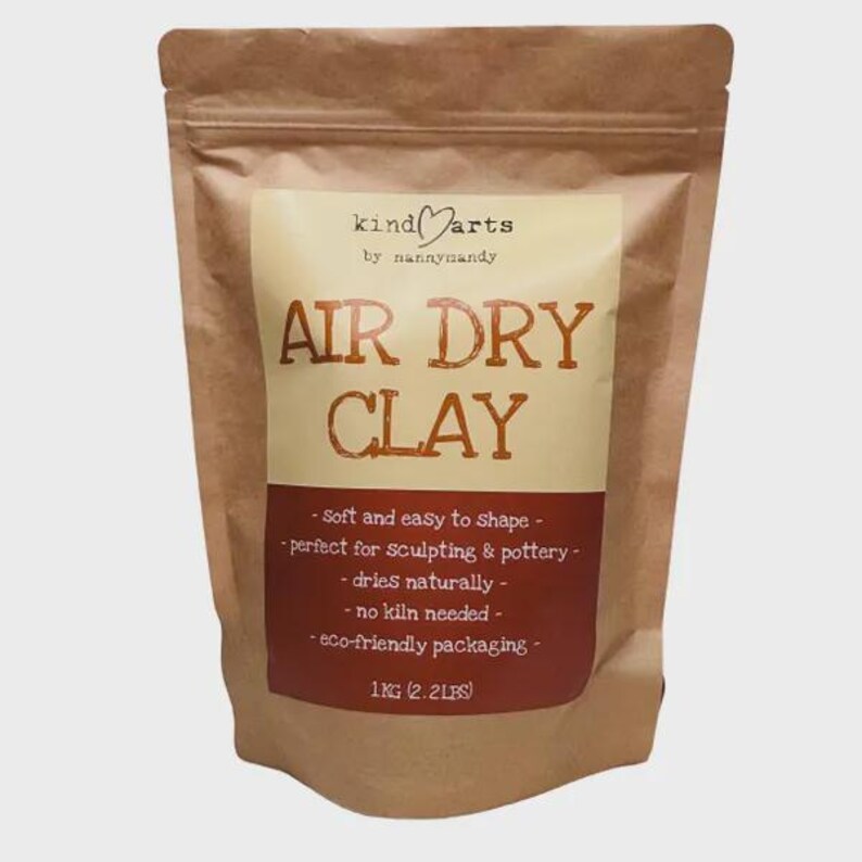 May include: A brown paper bag of air dry clay. The label reads "kind arts" and "Air Dry Clay". The bag also states the clay is soft and easy to shape, dries naturally, and requires no kiln. The bag contains 1 KG (2.2 LBS) of clay.