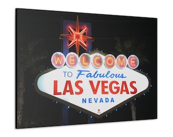 May include: Canvas print of the iconic "Welcome to Fabulous Las Vegas Nevada" sign at night. The sign features a white background with red and blue text, and is illuminated by neon lights. A red star is at the top.