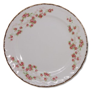 May include: White ceramic plate with a scalloped edge and a gold rim. The plate is decorated with a pattern of pink roses and green leaves. A classic design for serving food.