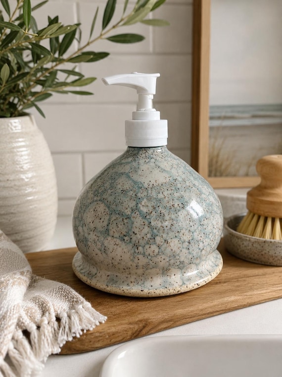 Handmade stoneware soap dispenser with a dreamy bubble glaze finish — the kind of thing that makes a kitchen sink feel intentional and curated.