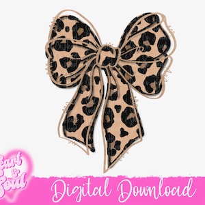 May include: A large brown and black leopard print bow with a slightly distressed look. The bow is tied in a knot and the ends are flowing.