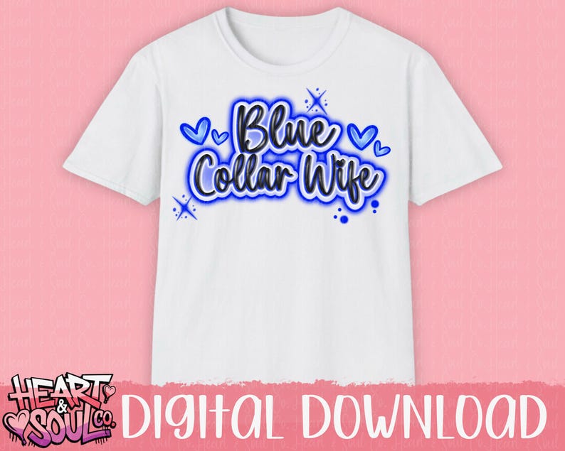 Puede incluir: Camiseta blanca con el texto "Blue Collar Wife" en azul, delineado en azul m&aacute;s oscuro. El dise&ntilde;o incluye corazones azules y detalles de estrellas. La camiseta se muestra sobre un fondo rosa.