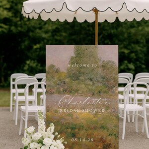 K&ouml;nnte beinhalten: Eine Hochzeitsfeier im Freien mit einem Schild mit der Aufschrift "welcome to Charlotte's Bridal Shower" und dem Datum 08.14.26. Wei&szlig;e St&uuml;hle und ein wei&szlig;er Schirm mit gewelltem Rand sind zu sehen. Ein Blumenarrangement aus wei&szlig;en Rosen befindet sich im Vordergrund.