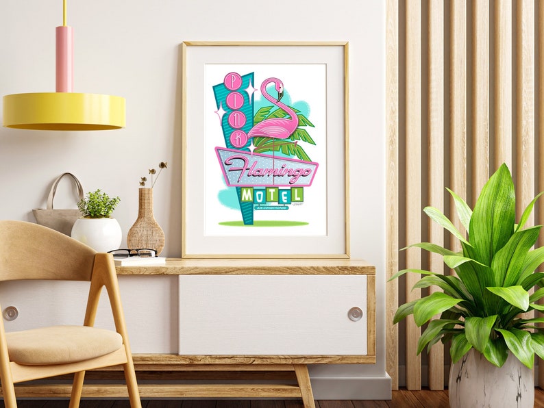 Puede incluir: Una impresi&oacute;n enmarcada de un flamenco rosa de pie sobre una palmera con un letrero de ne&oacute;n que dice "Flamingo Motel". El letrero es de estilo retro con colores rosa, azul y verde.