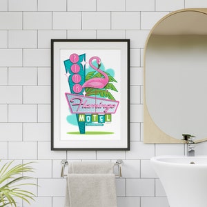 Puede incluir: Una ilustraci&oacute;n enmarcada de un flamenco rosa de pie sobre una palmera con un letrero de motel retro que dice "Flamingo Motel" con las palabras "Air Conditioned" debajo. El letrero tiene un contorno de ne&oacute;n rosa y las palabras "Pink" est&aacute;n escritas en luces de ne&oacute;n sobre el flamenco.