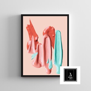 May include: Framed art print featuring abstract paint strokes in coral, pink, and teal against a pale peach background. The artwork has a modern aesthetic, with thick, textured paint applications. The frame is black, and the print includes a logo in the bottom right corner.