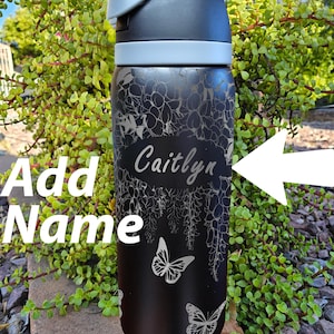 Puede incluir: Botella de agua de acero inoxidable negro con un diseño floral y mariposas. El nombre "Caitlyn" está grabado en la botella.