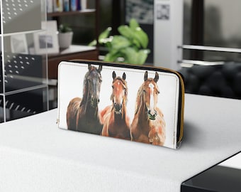 May include: White leather zippered wallet with a colorful illustration of three horses running. The horses are brown and white with black manes and tails.