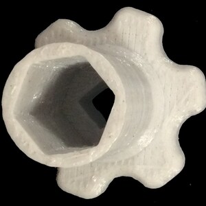 Pu&ograve; includere: Ingranaggio in plastica bianca con un foro esagonale al centro. L'ingranaggio ha cinque punti.