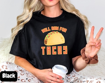 Pode incluir: Camiseta preta com um gráfico de um taco e o texto "Will Run For Tacos".