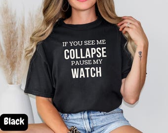Pode incluir: Camiseta preta com texto branco que diz "Se você me ver desmaiar, pause meu relógio."