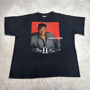 May include: Black t-shirt featuring a portrait of Nathan Morris from Boyz II Men on a red background. The shirt includes the text "ALEXANDER REID" and "Boyz II Men" in white lettering.