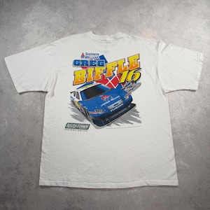 May include: White t-shirt with a graphic of a blue and white race car, the text "Greg Biffle 16", and "Sherwin Williams". The shirt also features the "Roush Fenway Racing" logo.