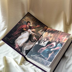 May include: An open book with two illustrations. The left page shows a man in red and gold clothing holding a woman in a white dress. The right page shows a group of people in medieval clothing, including a king sitting on a throne.